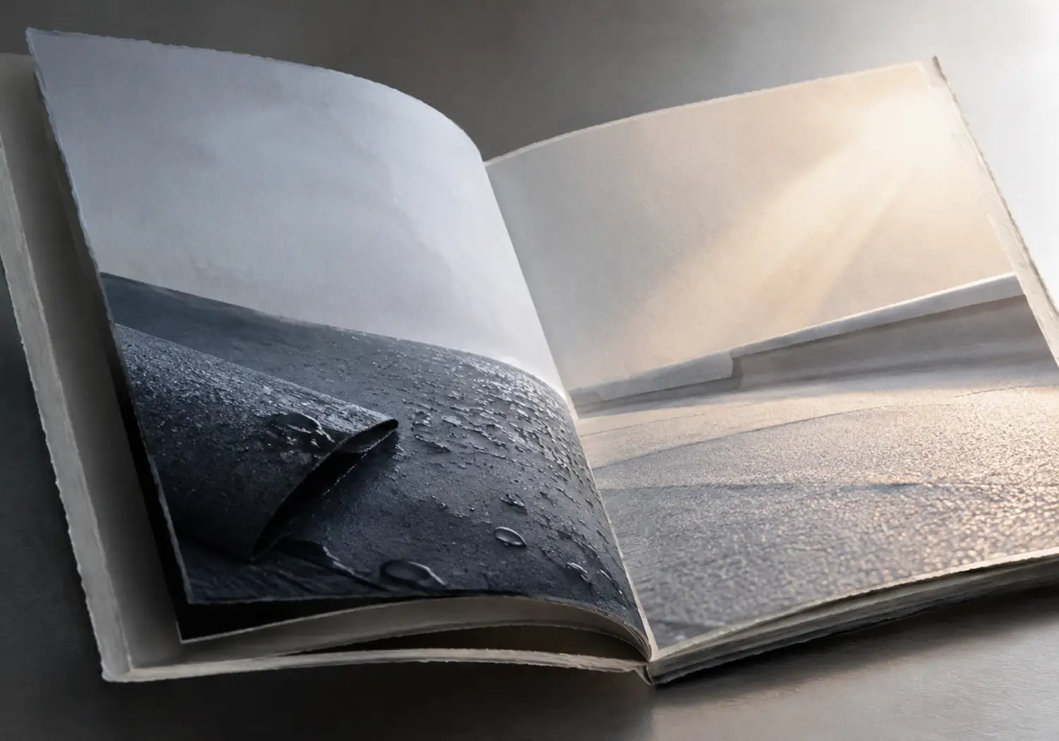 Libro escultórico abierto que contrapone una cubierta mojada bajo luz fría y la misma textura al secarse